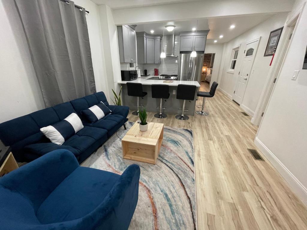 泽西市Modern Luxury Apartment near NYC的一间带蓝色沙发的客厅和一间厨房