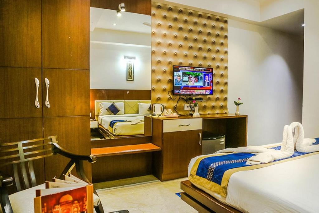 阿格拉泰姬陵高地酒店的一间卧室配有两张床,并在房间内配有电视