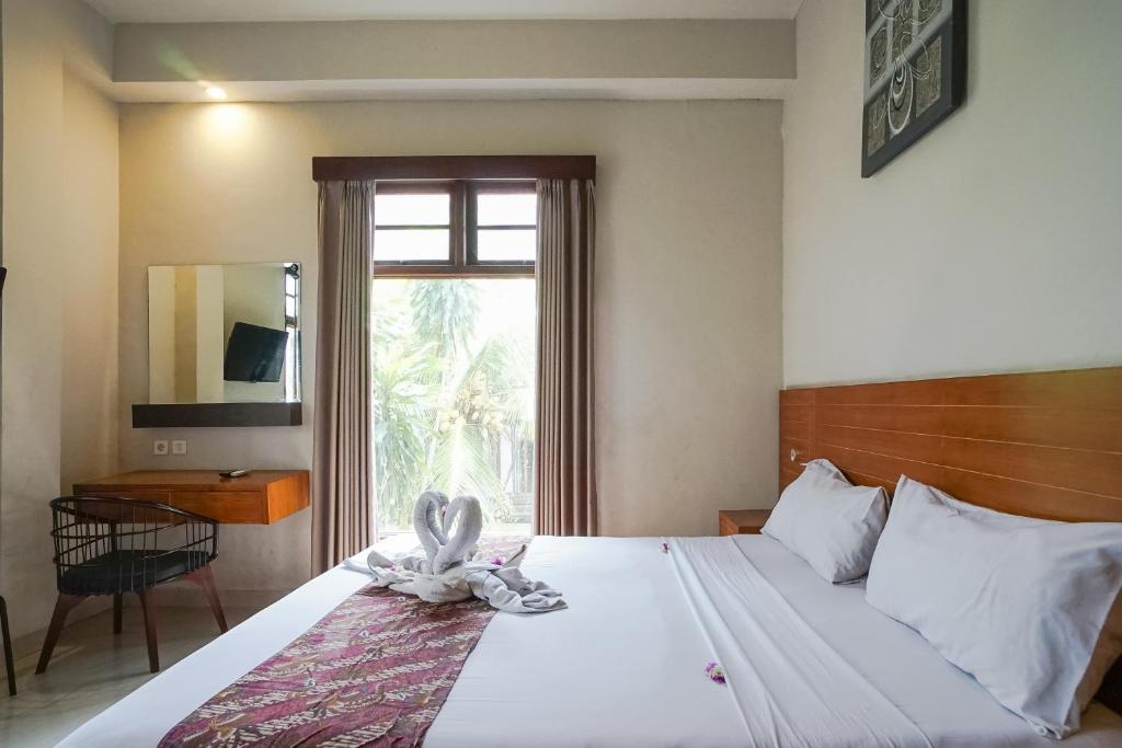 沙努尔阿卡萨特兰西特酒店的卧室里设有一张床,上面有一只动物