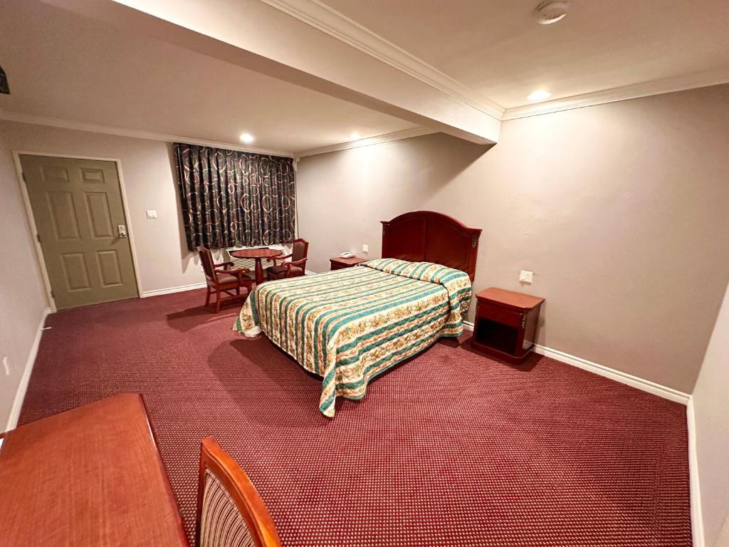 BellTropic West Motel的酒店客房配有一张床铺和一张桌子。