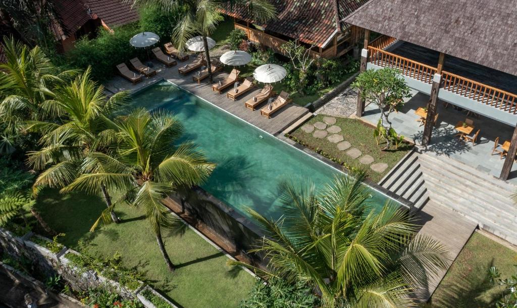 乌布RUMAH KAYU RESORT的享有棕榈树游泳池的顶部景致
