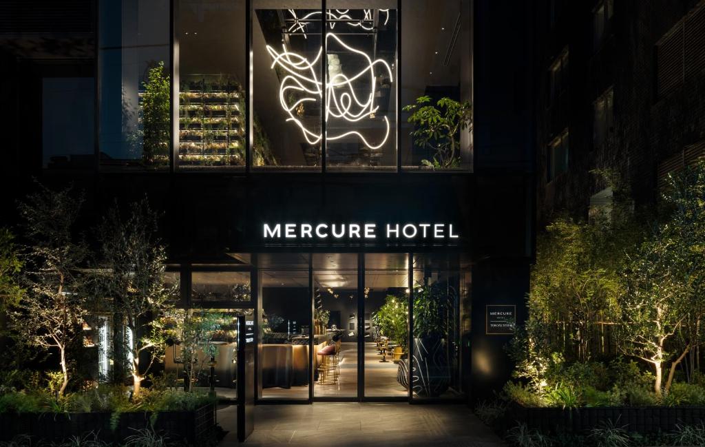 大阪Mercure Tokyu Stay Osaka Namba的夜间有 ⁇ 虹灯标志的美丽酒店