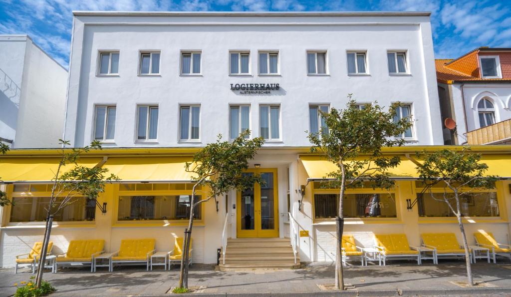 诺德奈乐格瑞和斯奥斯特尼非茶酒店的前面有橙色椅子的白色建筑