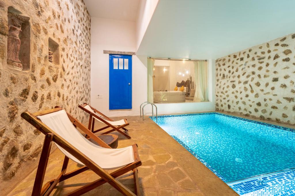 蓬蒂切里Conch Resort Luxury Private Pool Suites的游泳池位于隔壁带两把椅子的房间