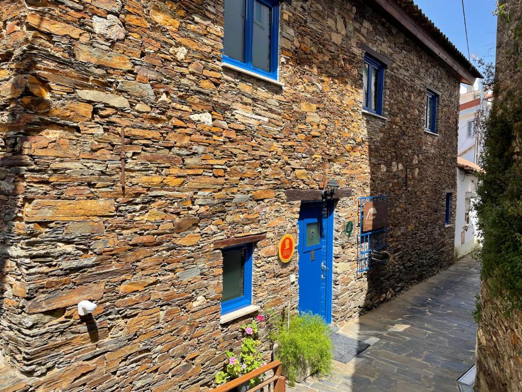 阿加尼尔Campus Natura的街上有一扇蓝色门的石头建筑