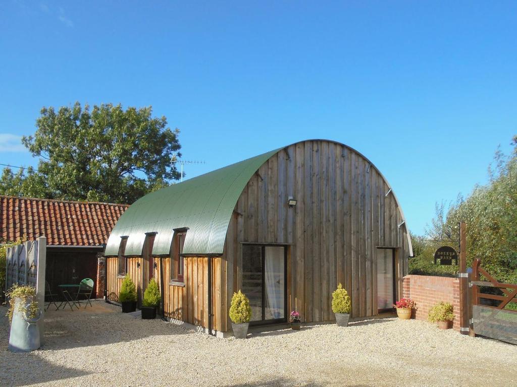 布伦特山庄Hollys Barn的一个带绿色屋顶的大型木制谷仓
