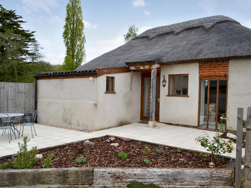 BlofieldThe Cowshed的白色的小房子,带有茅草屋顶