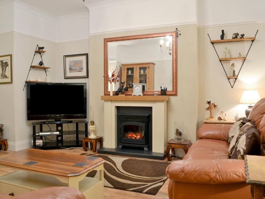 亨斯坦顿Chestney House的客厅设有壁炉和电视。