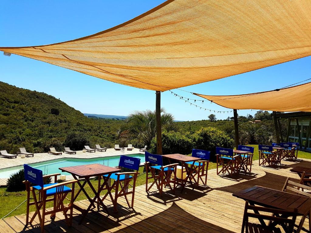 塞拉纳镇Villa Serrana - Mesón de las cañas的一个带桌椅的庭院和一个游泳池