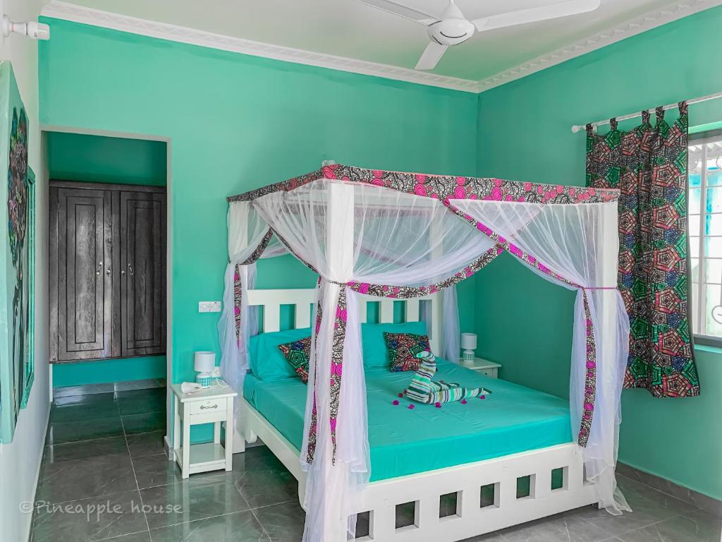 南威Pineapple House的一间拥有蓝色墙壁的卧室和一张带天蓬的床
