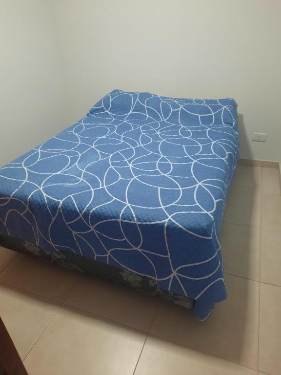 MacachínKyomu Departamento的一张铺有蓝色棉被的床