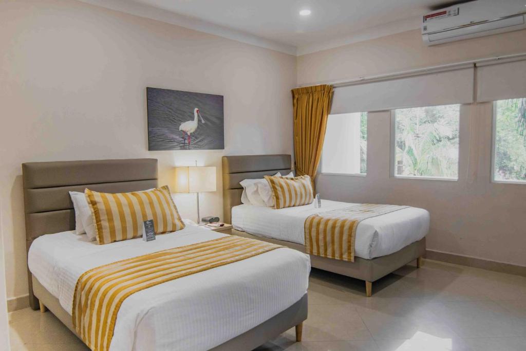 内瓦Hotel Neiva Plaza的酒店客房设有两张床和窗户。