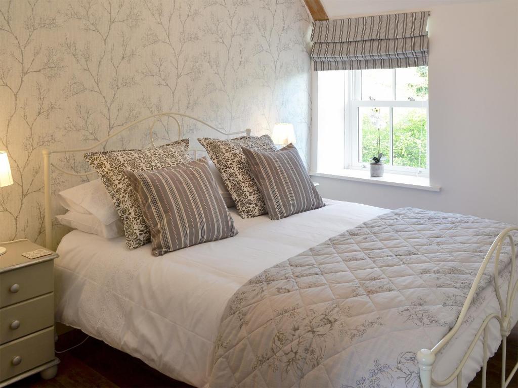SmeafieldMelandra的卧室配有带枕头的白色床和窗户。