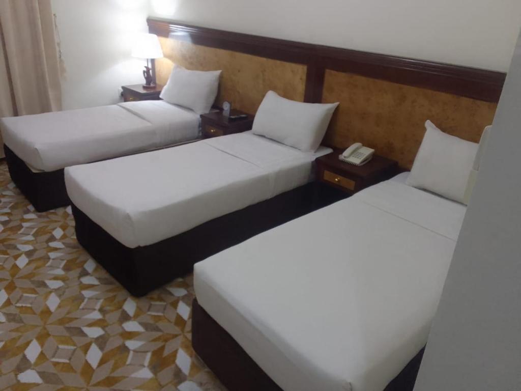 Al ‘Azīzīyahاوتاد المتحدة的配有白色床单的酒店客房内的两张床