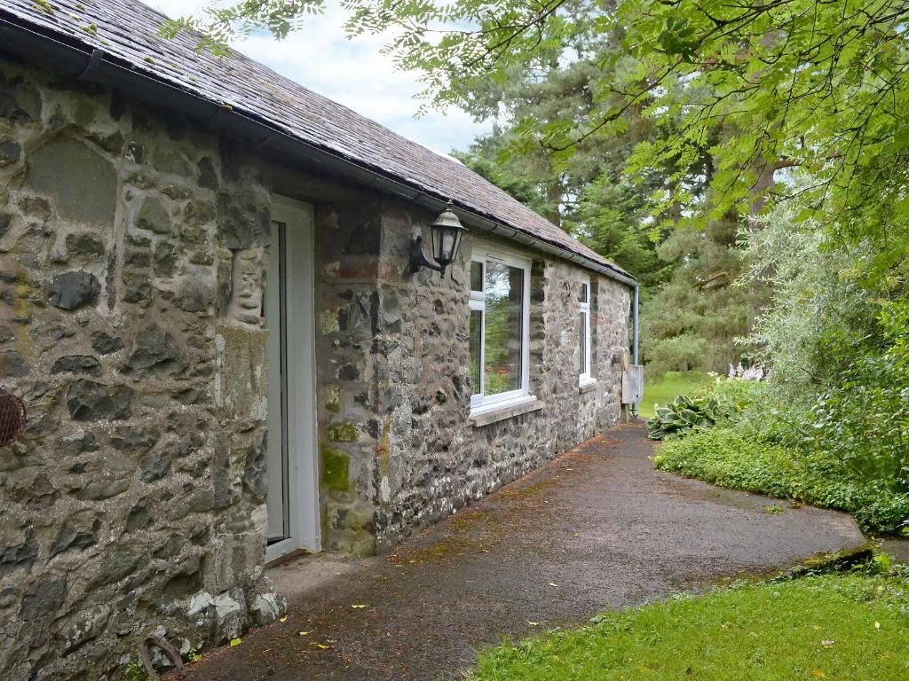 莫法特Dye Mill Cottage的石头建筑,有门和窗户