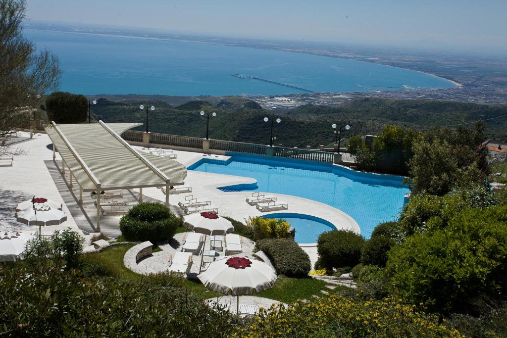 圣安吉罗山圣米歇尔宫酒店的一个带椅子和遮阳伞的游泳池以及大海