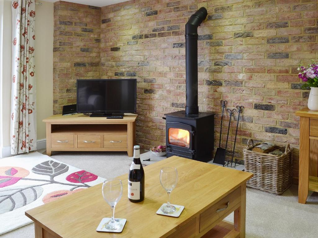 MatfieldDairy Cottage的客厅配有带2个酒杯的木炉