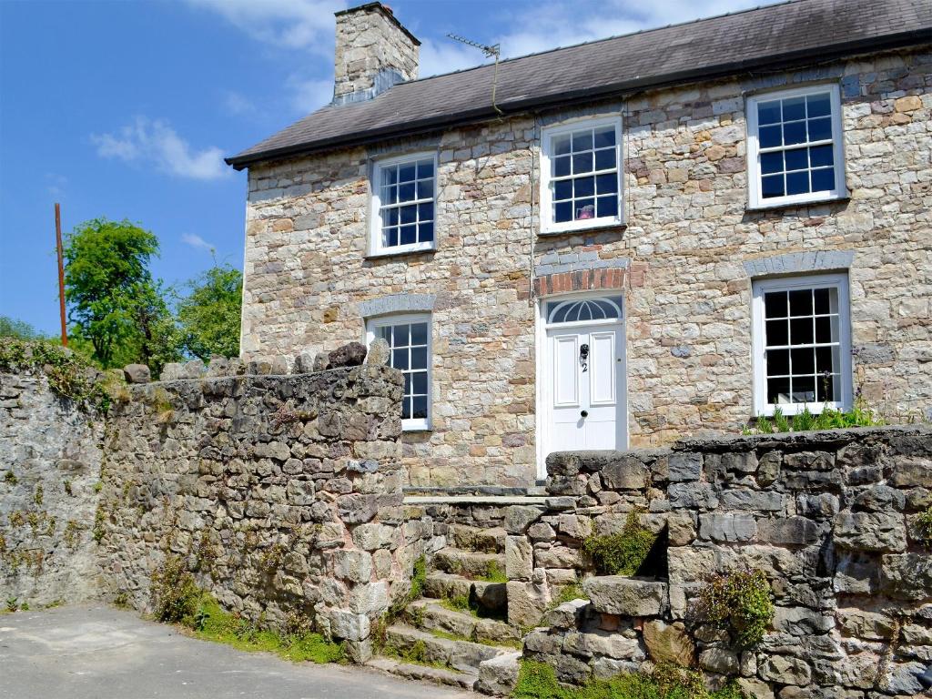 LlandybieThe Mill Farmhouse的一座石墙的古老石屋