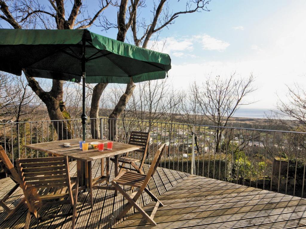 彭代恩Seacrest Cottage - Hw7746的甲板上配有一张木桌和椅子及遮阳伞