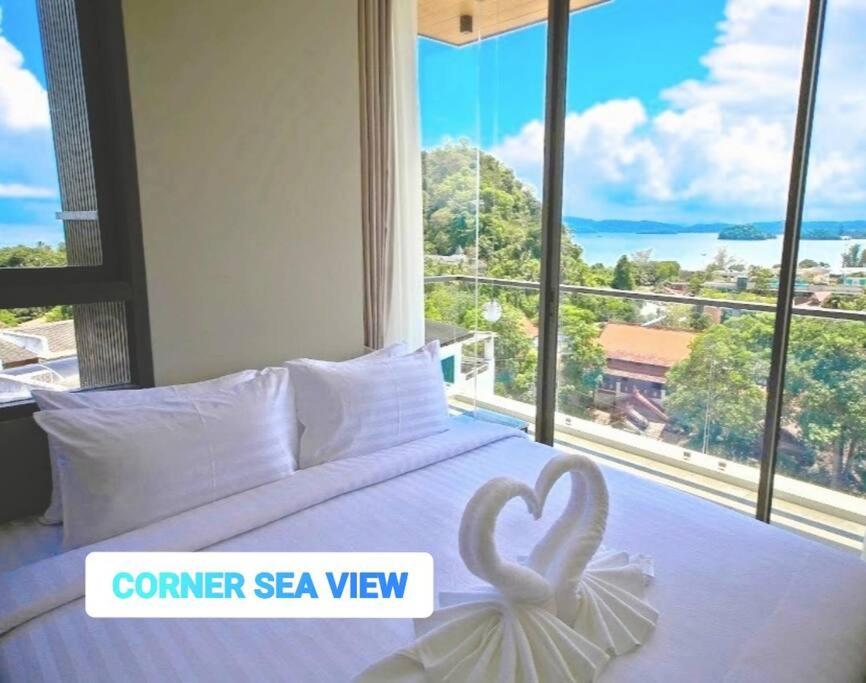 奥南海滩CORNER SEA VIEW KRABI Ao Nang 4 STARS HOTEL RESIDENCE的一间卧室设有一张大床和大窗户