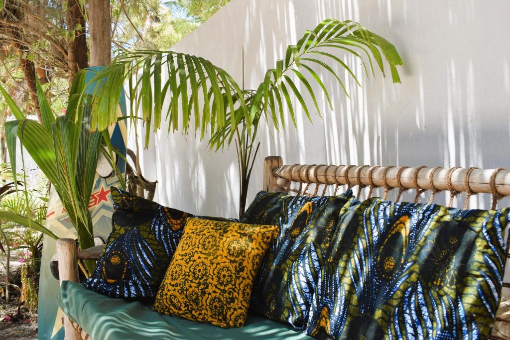 布韦朱Maryam Garden Apartments & Villa的坐卧在植物旁的沙发,带枕头
