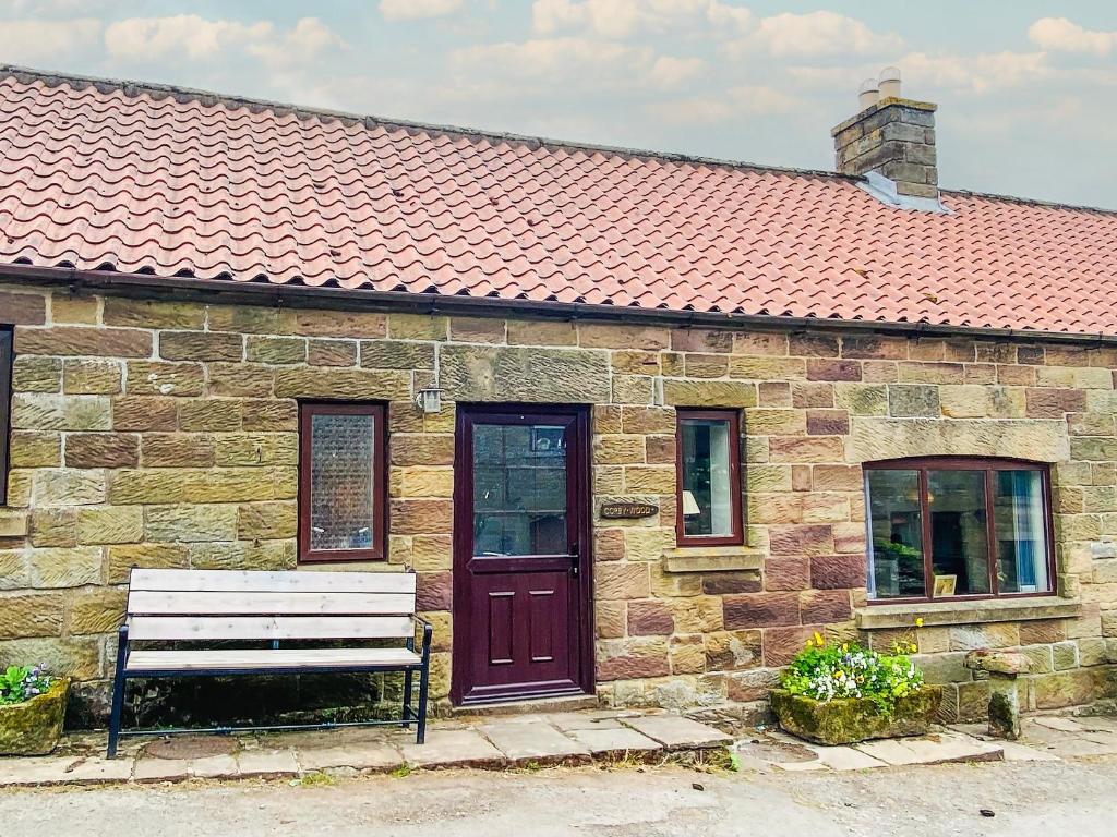 Rosedale Abbey科比伍德乡村别墅的石头建筑,带长凳和红色屋顶