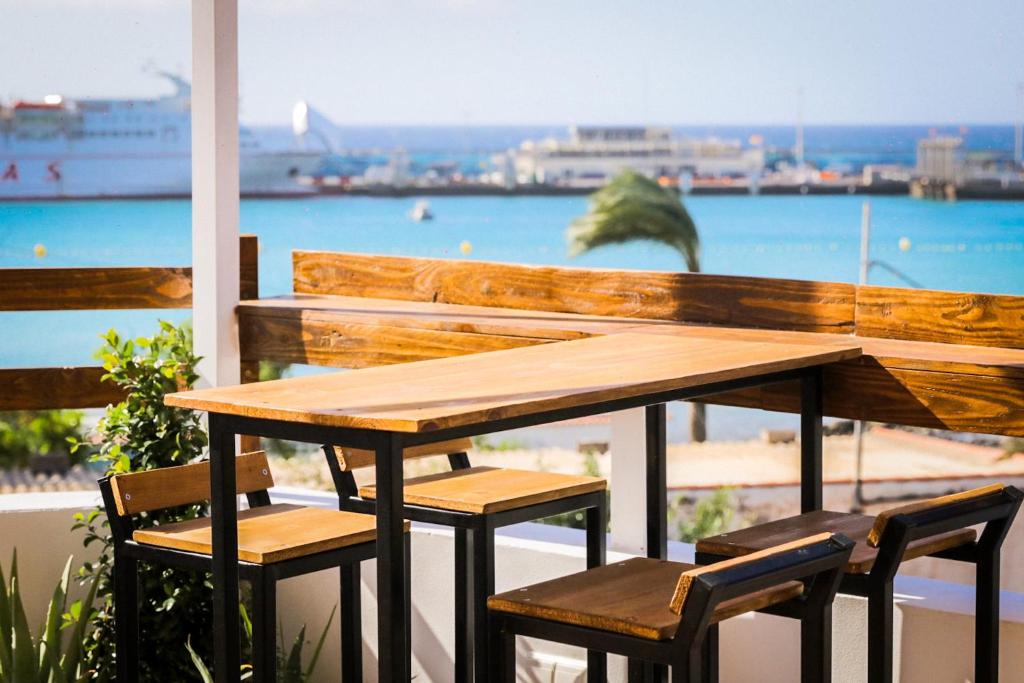 阿罗纳Ocean Nomads Coworking的阳台上配有一张木桌和椅子,享有海景