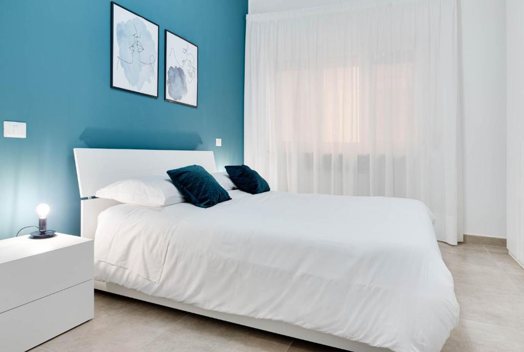克罗托内Jòia Holiday Home的卧室配有白色的床和蓝色的墙壁