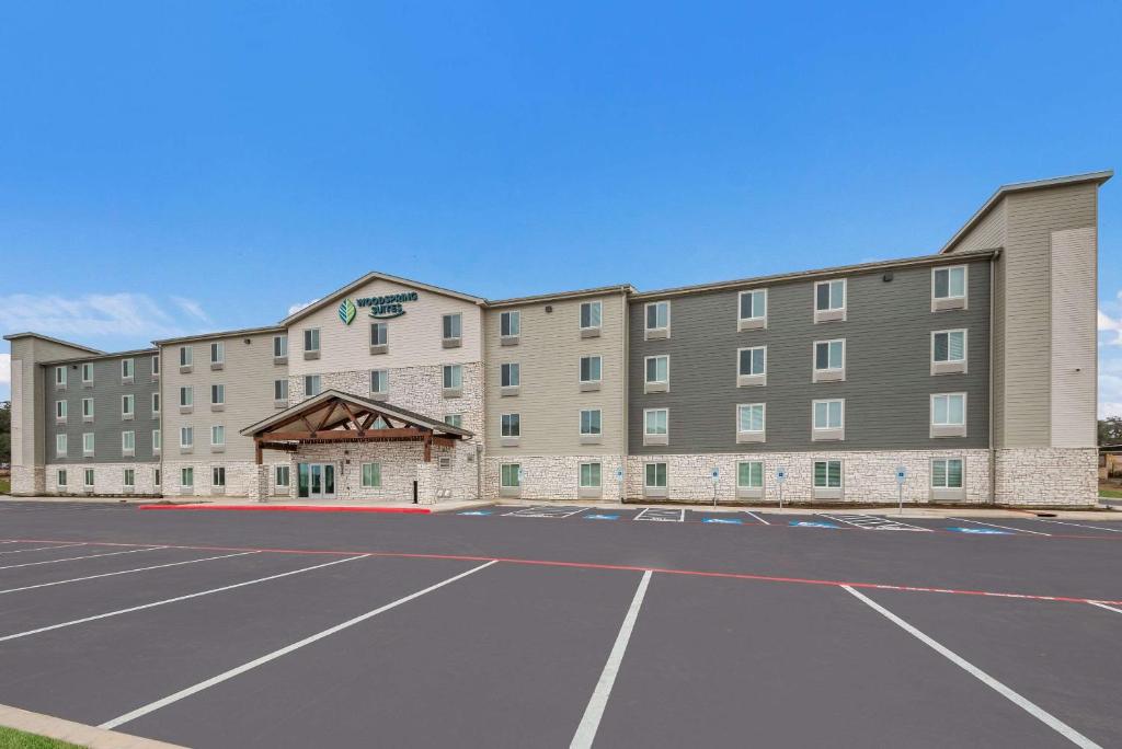 圣安东尼奥WoodSpring Suites San Antonio UTSA - Medical Center的前面有一个停车位的酒店