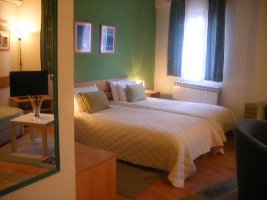 斯科普里7号酒店的一间卧室设有一张大床和一个窗户。