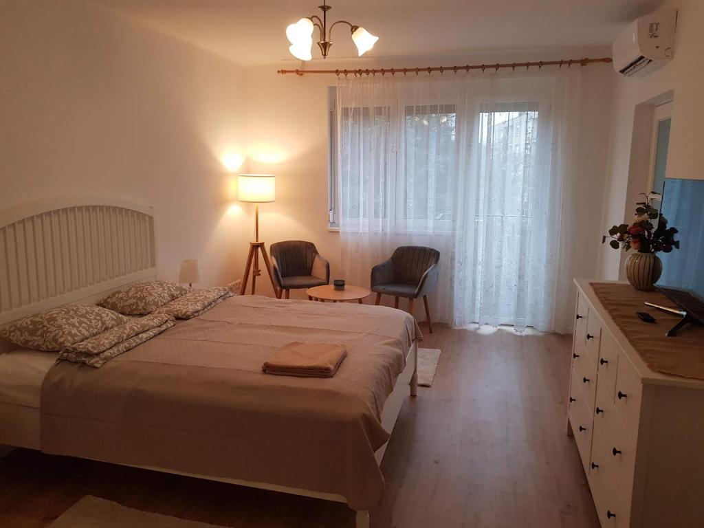 艾斯特根Kislakás Esztergomban的一间卧室配有一张床、一张书桌和一个窗户。