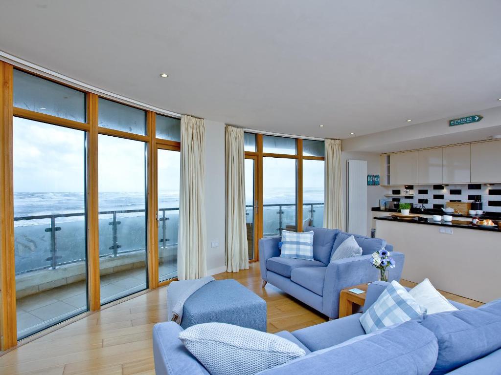 韦斯特沃德霍Pebbles, Horizon View的客厅设有蓝色家具和大窗户