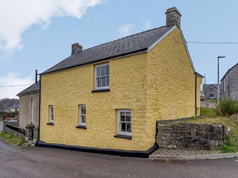 布里真德Yellow Welsh Cottage-Coastal Retreat Village View的街上有黑色屋顶的黄色房子