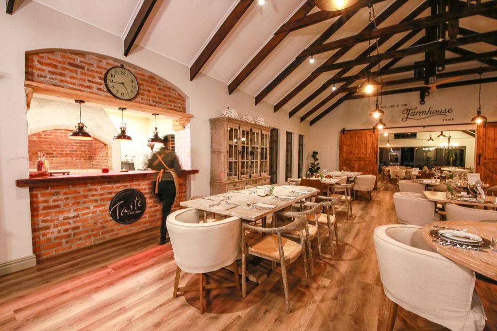 奥奇瓦龙戈欧吉瓦萨法里山林小屋的餐厅设有桌椅和墙上的时钟