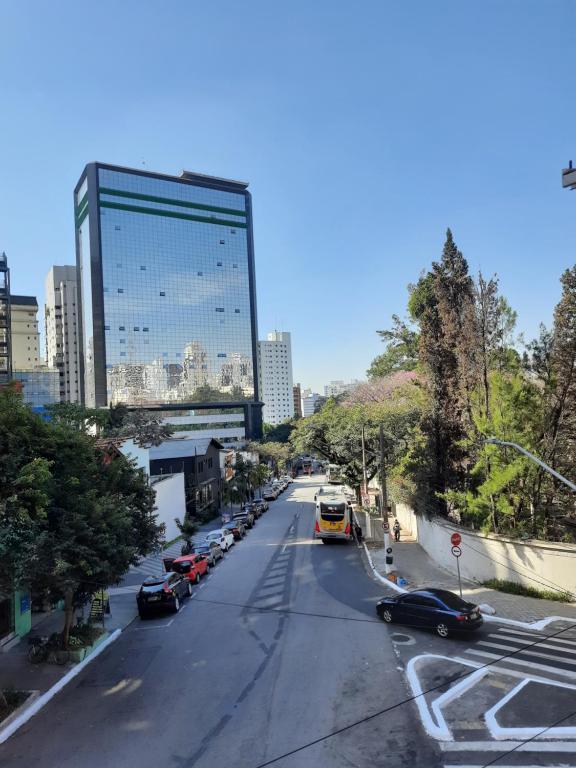 圣保罗Hotel sany - Localizado à 5 minutos do Metrô Paulista的一条有汽车的城市街道和一座高大的建筑
