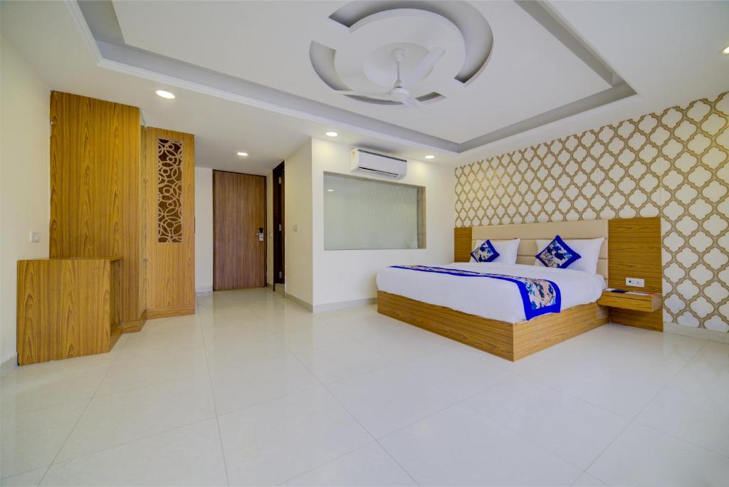 新德里Hotel Decent Suites - Delhi Airport的一间设有床铺和天花板的大卧室