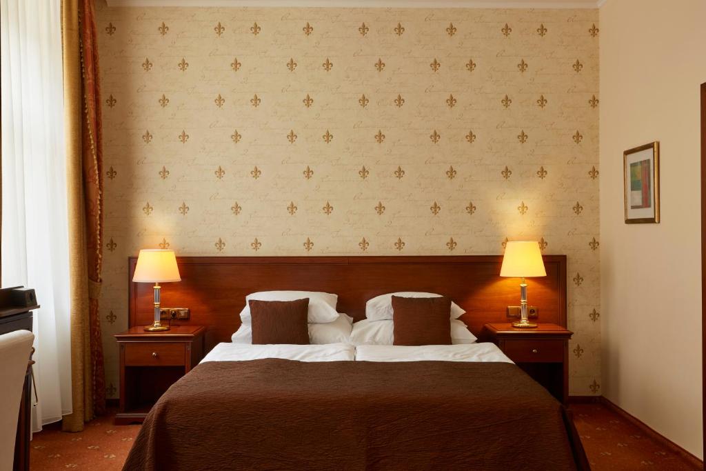 布拉格FLEUR DE LIS HOTEL的一间卧室配有一张大床和两盏灯
