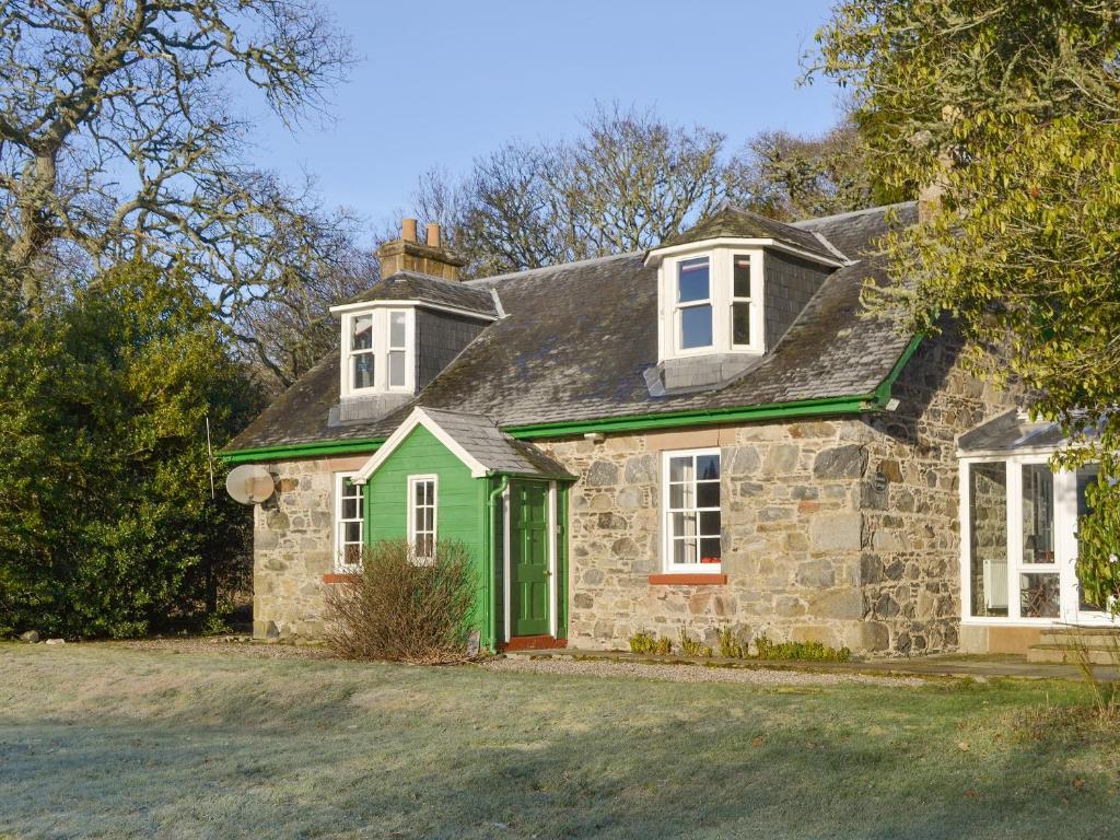 BelladrumKennels Cottage - Beaufort Estate的一座带绿门的古老石屋
