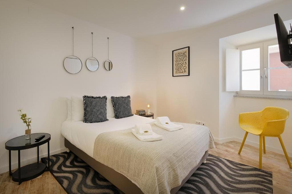 埃武拉Almoura Ladeira的白色卧室,配有床和黄色椅子