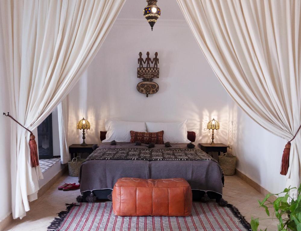 马拉喀什Riad Al Wifak的一间卧室配有床、窗帘和地毯