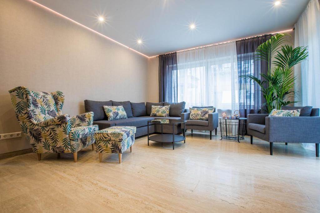 巴登-巴登Modernes Apartment in Zentrumsnähe mit eigenem Stellplatz的客厅配有蓝色的沙发和椅子