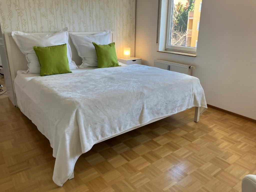 路德维希堡Ferienwohnung-Ludwigsburg-City的一张带绿色枕头的大白色床