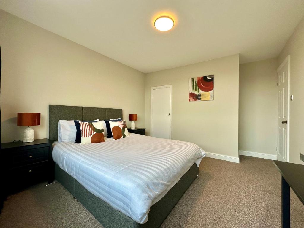 比斯特Spacious 3 double bedroomed house in Bicester的一间卧室配有一张带白色床单的大床