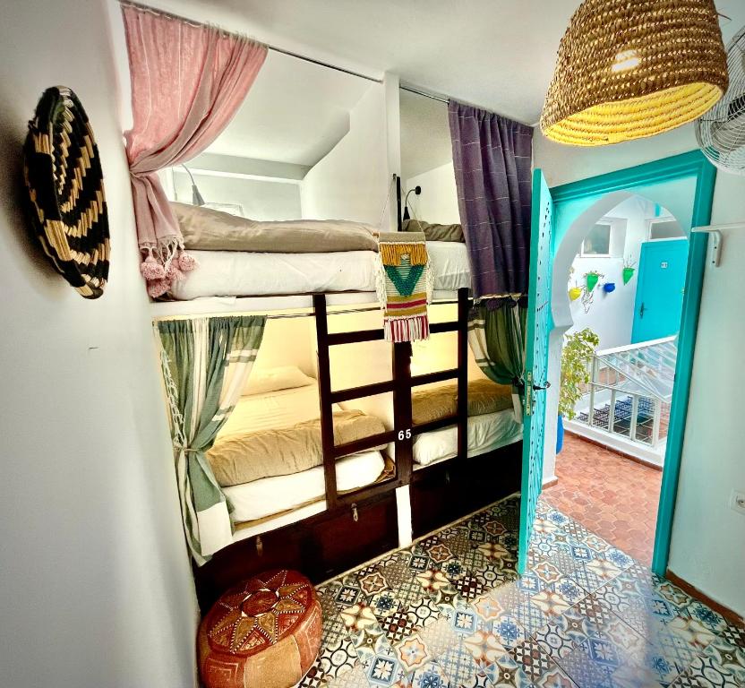 得土安Darna Hostel的一间带两张双层床的房间和一间带镜子的房间