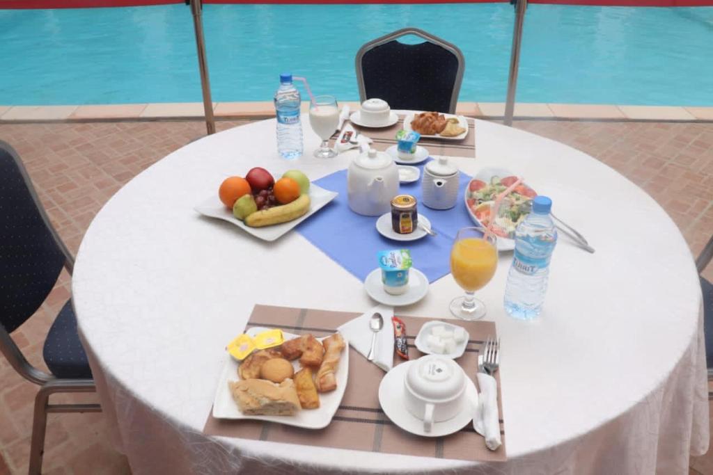 努瓦克肖特Hotel Hayatt的一张带食物和饮料的白色桌子
