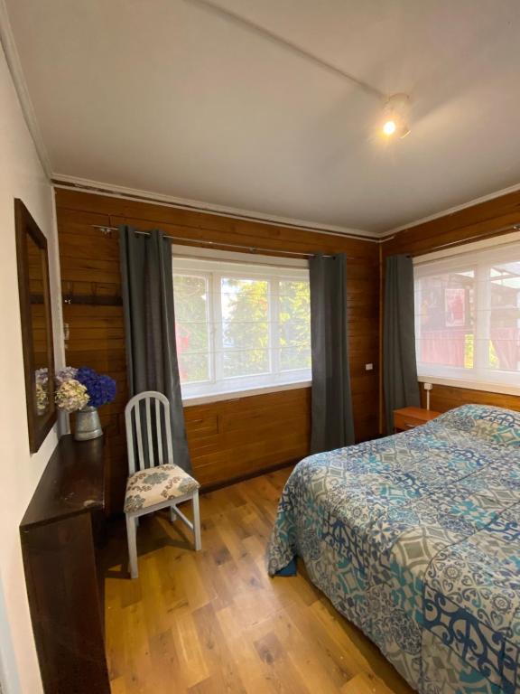 巴拉斯港La Guapa Hostel的一间卧室配有一张床、一把椅子和窗户。