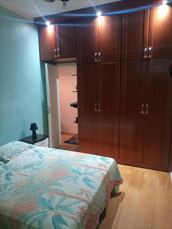 里约热内卢Catete 247的一间卧室配有一张床和木制橱柜