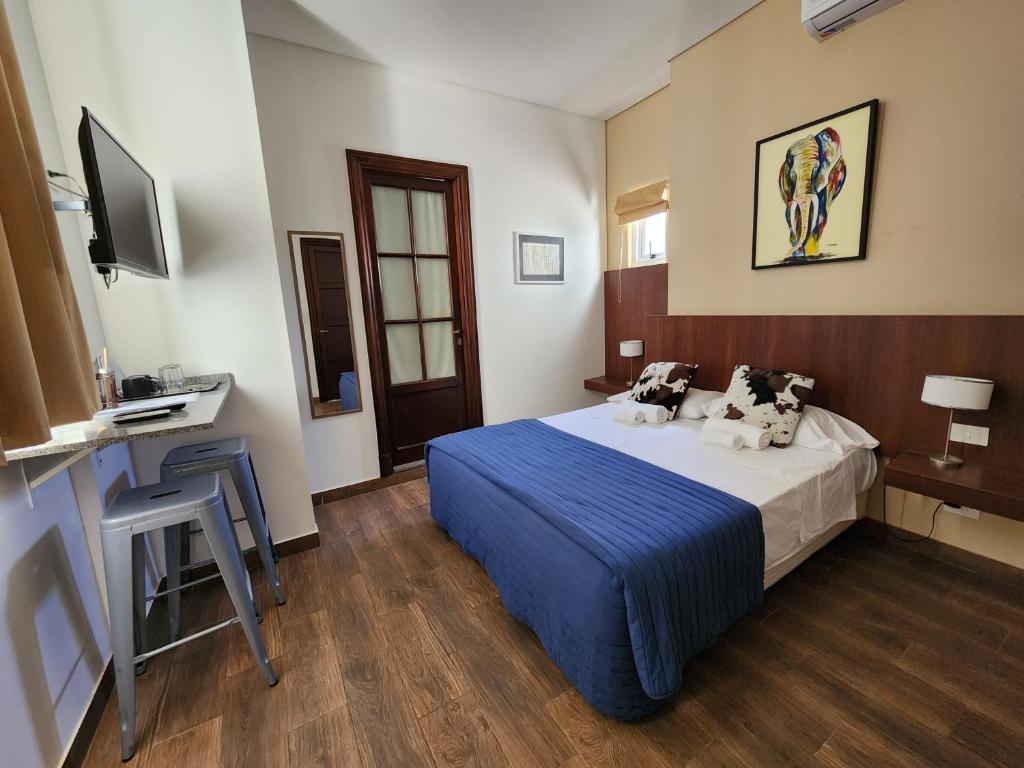 布宜诺斯艾利斯Habitaciones en Suite Balcarce的配有一张床和一张书桌的酒店客房