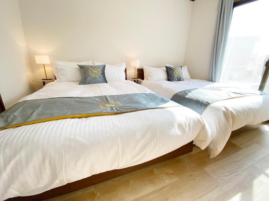 高知The Domain的带窗户的客房内设有两张单人床。
