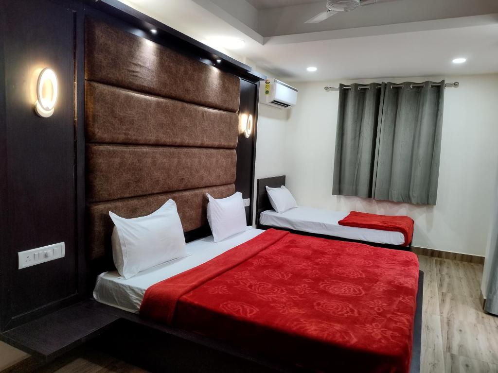 巴加C V Inn的配有红色毯子的酒店客房内的两张床